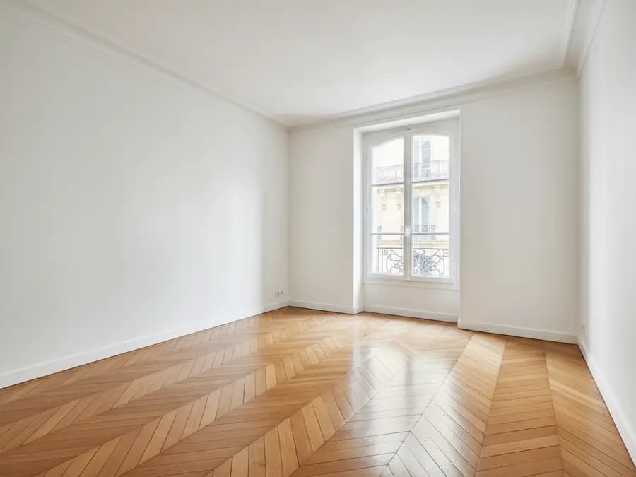 Pièce entièrement vidée après un débarras, parquet et murs nus