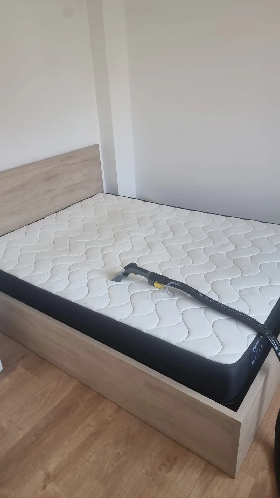 Matelas nu en cours de traitement, embout de nettoyage professionnel posé dessus