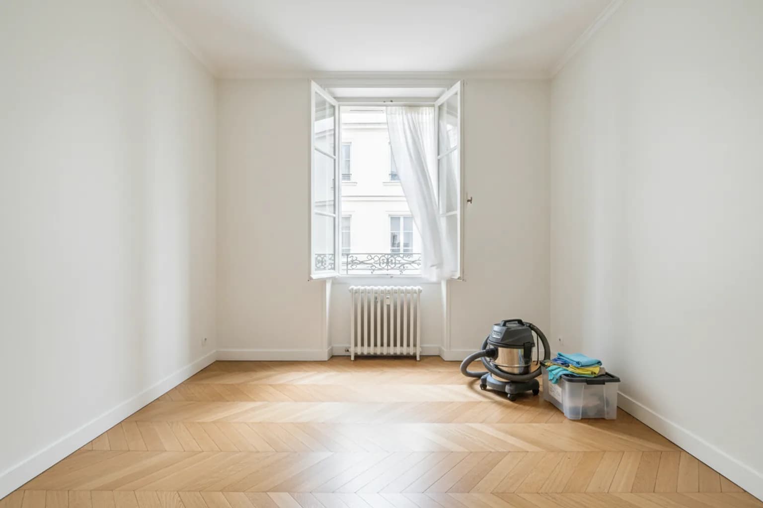 Pièce vidée et nettoyée après une intervention, fenêtre ouverte et matériel professionnel rangé