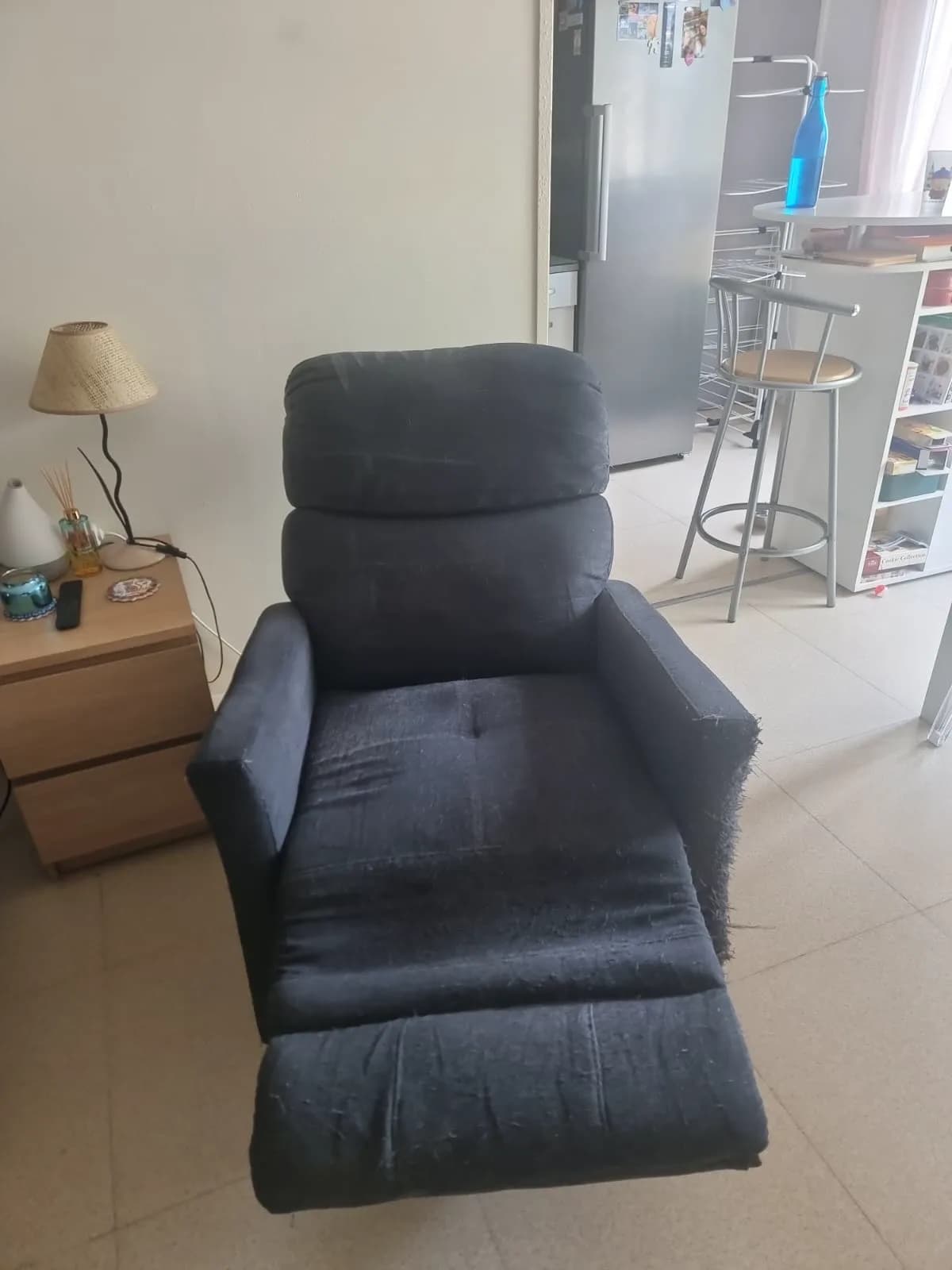 Le même fauteuil après nettoyage : le tissu est redevenu uniforme, l'accoudoir reste usé